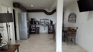 A compact kitchen with a refrigerator, microwave, and sink. There is a dining area with a table and chairs. - Relaxing Lake Travis waterfront apartment with boat launch (Austin)