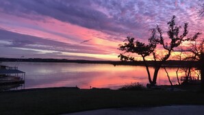 A lakeside view with a dock and a covered seating area. - Relaxing Lake Travis waterfront apartment with boat launch (Austin)