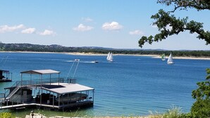 A waterfront property with a covered dock and a building with outdoor seating. - Relaxing Lake Travis waterfront apartment with boat launch (Austin)