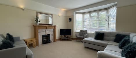 Cozy up by the fireplace in this inviting living room, featuring a TV and two comfortable sofas.