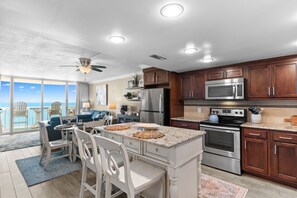 A modern kitchen with a central island, stainless steel appliances, and wooden cabinets.