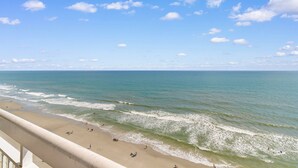 A beach with a clear sky and calm sea. - Garden City Beach Oceanfront Condo 1202 | Rising Tides Properties Rental (Murrells Inlet)