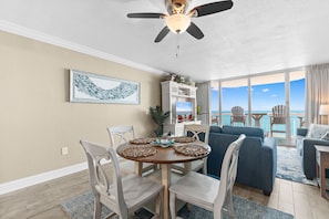 A dining area with a round table, chairs, and a ceiling fan.