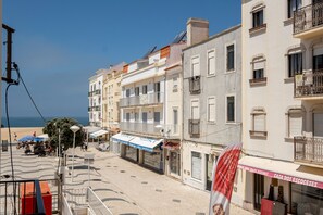 Eine Küstenstraße mit Gebäuden, Geschäften und freiem Blick auf das Meer.
