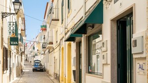 En kullerstensgata kantad av byggnader, bland annat med en skylt som visar nummer 8 och namnet TOFA.