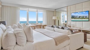 Una habitación de hotel con una cama grande, un escritorio y un televisor.
