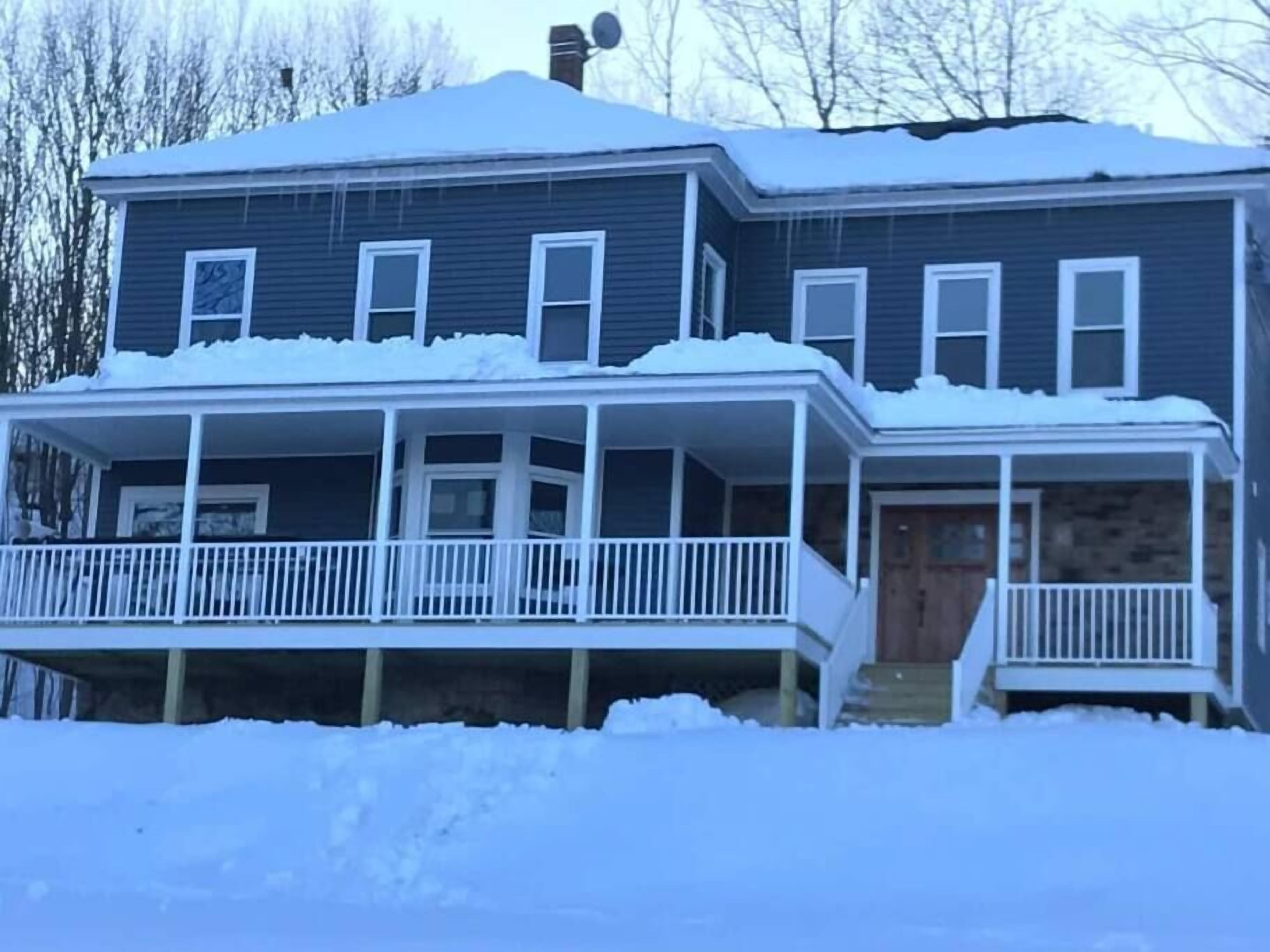A two-story house with a covered porch and a front door.