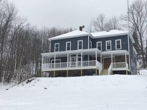 A two-story house with a covered porch and a staircase leading to the entrance. - Ride from this Mini Mansion to all the ATV Trails (Berlin)