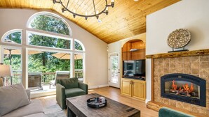 Un salón amplio con chimenea, ventanas grandes y una zona de estar acogedora.