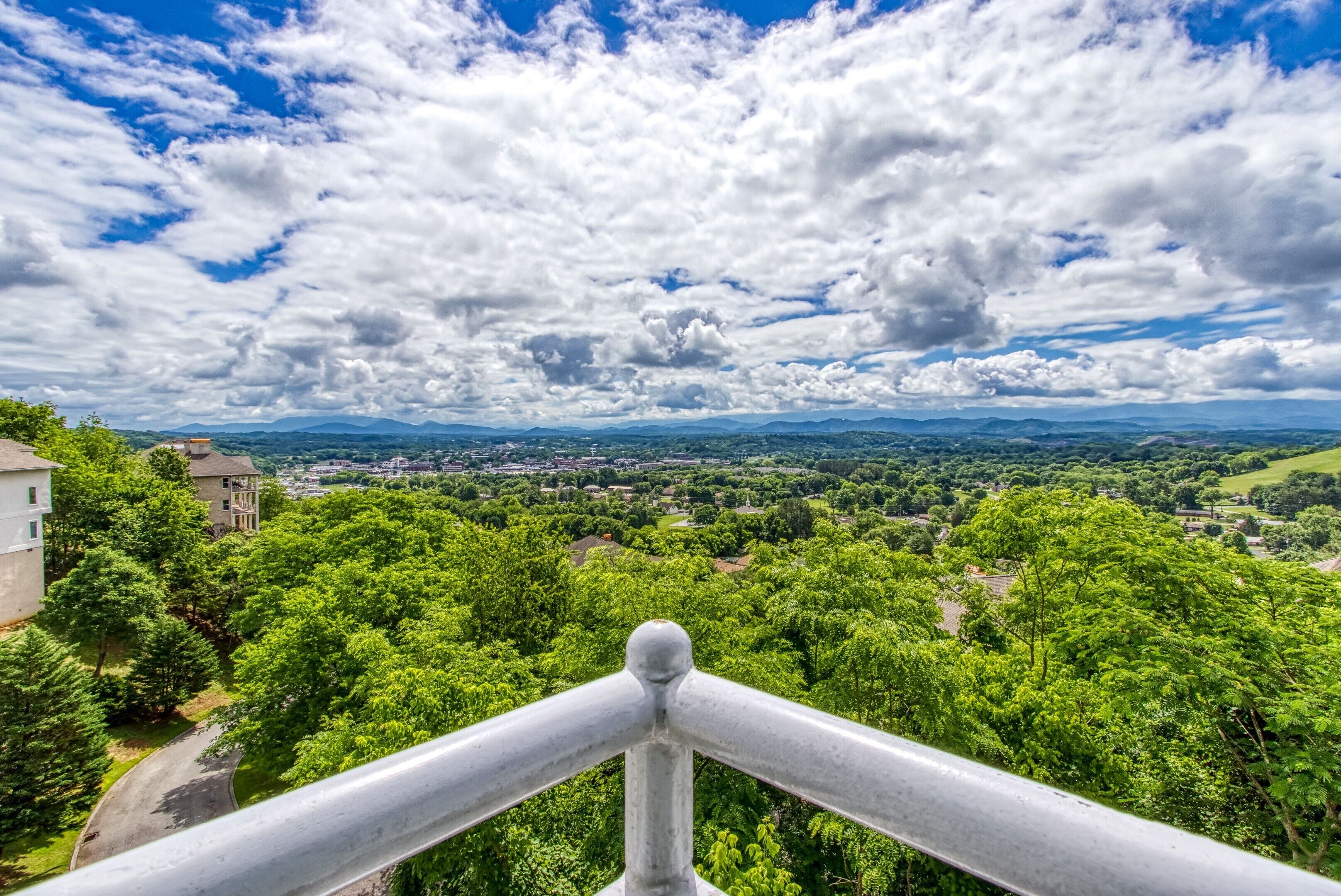 Ein weitreichender Blick auf eine üppige, grüne Landschaft mit blauem Himmel und vereinzelten Wolken.