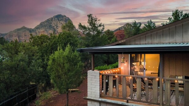 Ein modernes Haus mit einem Balkon mit Blick auf eine gebirgige Landschaft.