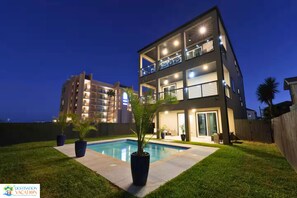 Un immeuble résidentiel moderne à plusieurs étages, avec une piscine en premier plan.