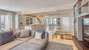 A modern living room with a sofa, a coffee table, and a bookshelf. - Modern Vail Village Ski-in Ski-Out Townhome (Vail)