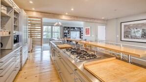A modern kitchen with a central island, built-in appliances, and a view to the outdoors. - Modern Vail Village Ski-in Ski-Out Townhome (Vail)