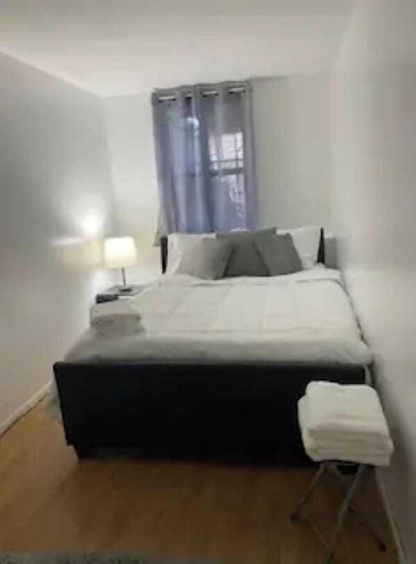 Cozy retreat with a single bed, nightstand, and comfortable seating area.