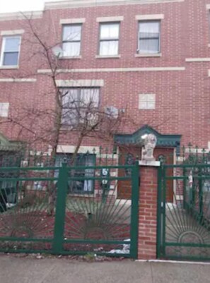 Stunning red brick building with a charming metal gate and ornate stone archway.