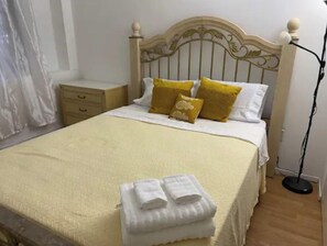 Restful retreat with a comfortable bed, featuring a headboard and plush bedding, along with a convenient nightstand and ample storage.