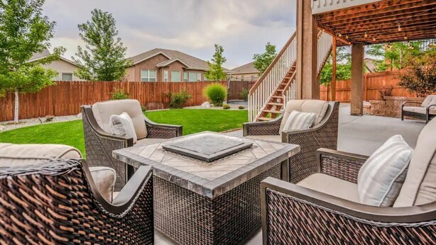 A patio area with wicker furniture, a fire pit, and a wooden deck.