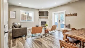 A spacious living room with a fireplace, a dining area, and a sofa.