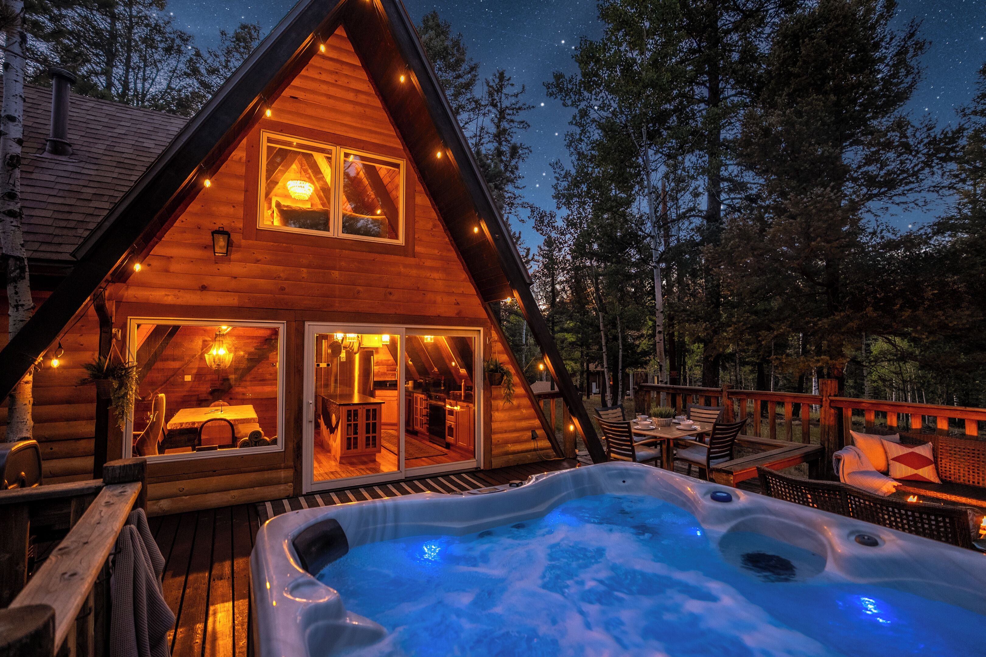 A log cabin with a hot tub and deck area.