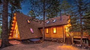 A log cabin with a sloped roof, multiple windows, and a wooden deck.
