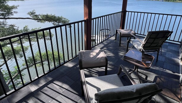 A wooden deck with outdoor furniture overlooking a lake. - Lakefront Luxury Modern Home With Docks, Fire Pit & Pontoon Boat Rental (Turtle Lake)
