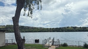 Ein Seeufergrundstück mit Steg, einem Weg zum Wasser und einem Baum.