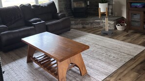 A living room with a sofa, a coffee table, a fireplace, and a television. - Spacious Home that is close to EAA and Shopping. (Oshkosh)