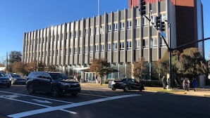 A modern building with a flat roof, large windows, and a red accent on the top right. - Easy walk to restaurants, coffee and ice cream shops, retail shopping, and more! (Tupelo)