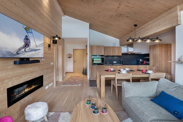 A modern living room with a fireplace, a television, and a sofa.
