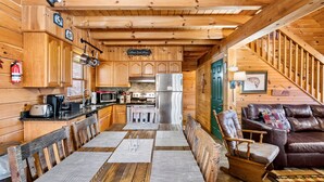 A wooden cabin interior with a kitchen, dining area, and living room. - Smokies Majestic Views | Hot Tub | Pool Table | Luxury Cabin (Sevierville)