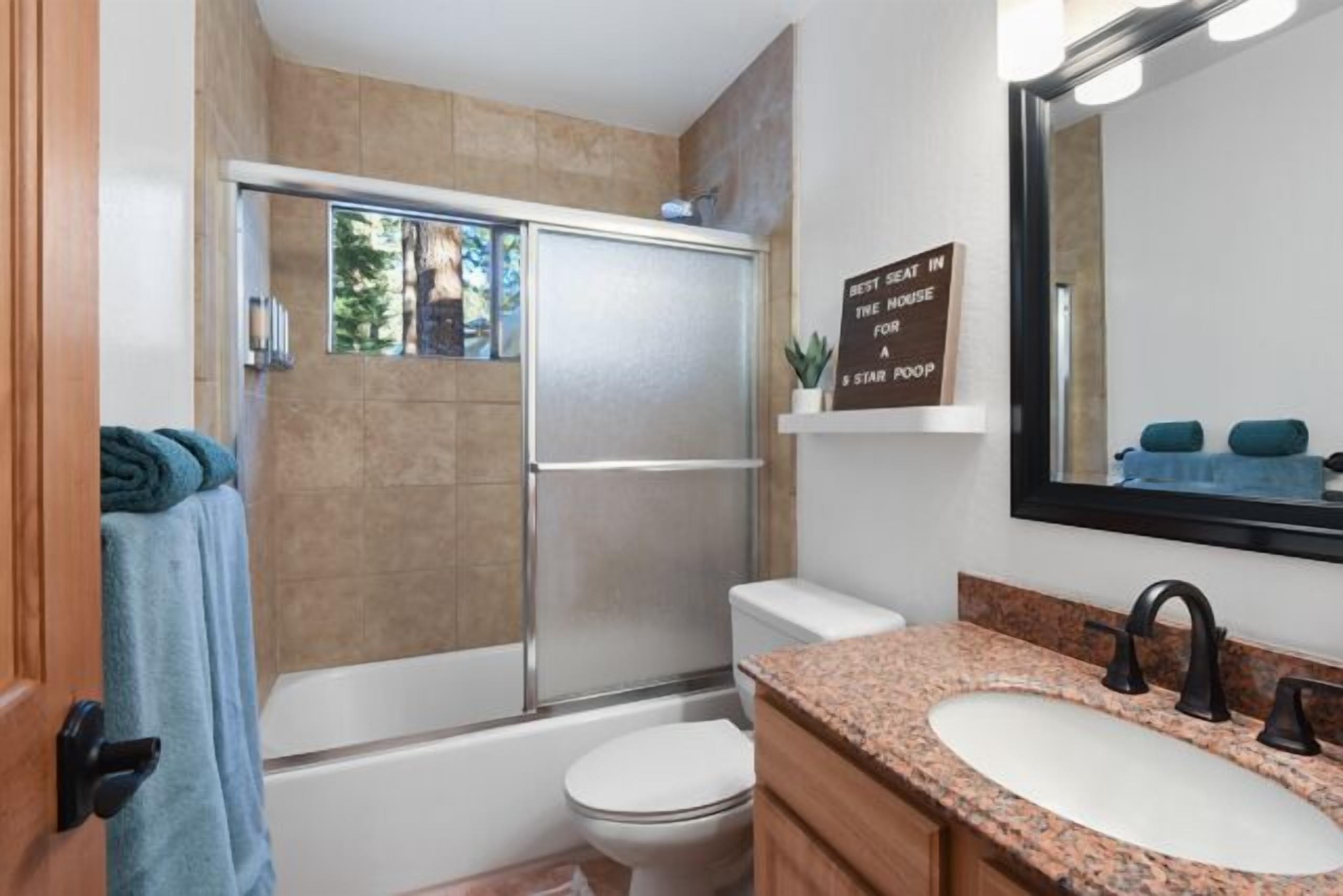A bathroom with a shower, toilet, and sink.