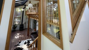 Ein modernes Interieur mit Dachfenster, Holzbalken und Blick ins Freie.