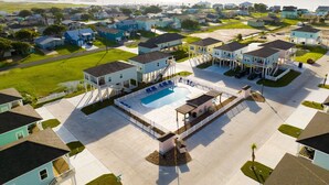 Zona residencial com casas, piscina e vista para o mar.