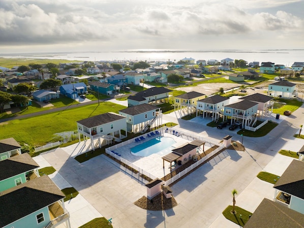 Un quartier résidentiel avec des maisons, une piscine et une vue sur l’océan.