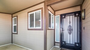 A house entrance with a decorative black door, a welcome mat, and two windows with shutters. - Fall Special! Private Pool/Spa! (Chandler)