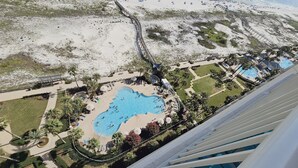 An aerial view of a resort with a large pool, palm trees, and a sandy beach. - Avalon 1707 King/Queen- Direct Gulf View - Wifi (Gulf Shores)