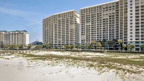 A beachfront hotel with multiple high-rise buildings, sandy beach, and palm trees. - Avalon 1707 King/Queen- Direct Gulf View - Wifi (Gulf Shores)