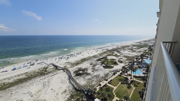 A beach resort with a wooden boardwalk, a pool area, and a view of the ocean. - Avalon 1707 King/Queen- Direct Gulf View - Wifi (Gulf Shores)