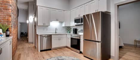 Enjoy cooking in this well-equipped kitchen with a dishwasher, microwave, oven, and refrigerator.