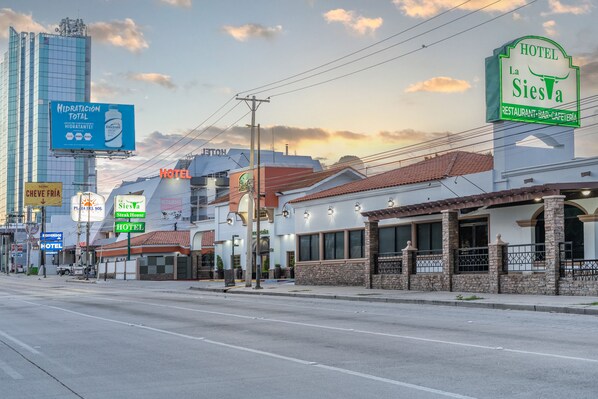 Vista de la calle con un hotel llamado 'La Siesva' y un restaurante 'Cheve Fria'.