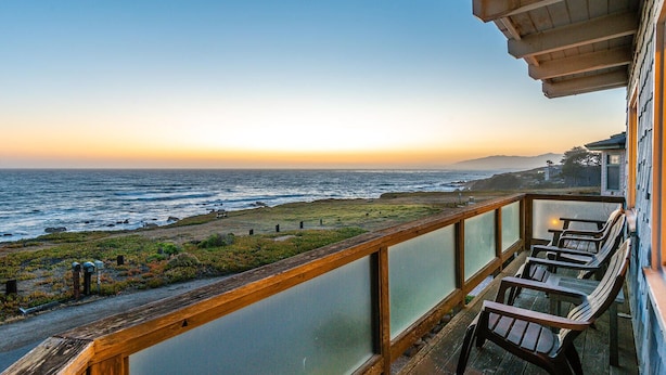 Ein Balkon mit Blick auf das Meer bei Sonnenuntergang.
