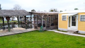 A waterfront property with a covered patio, a small boat dock, and a yellow building. -  Canal  access to the St. Johns River. Private boat dock. Parking for  trailer (Welaka)