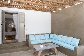 A modern interior with a sectional sofa, a small table, and a staircase leading to a bedroom.