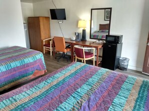 A hotel room with two beds, a desk, a chair, a television, a mirror, and a microwave. - ELDORADO MOTEL (New Castle)