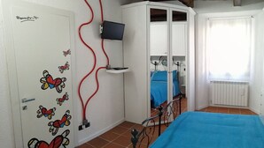 A bedroom with a bed, a wardrobe, a TV, and a window with curtains. - Beautiful apartment for 4 guests with WIFI, TV and pets allowed (Orta San Giulio)