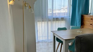 Una sala de estar moderna con comedor, un sofá, una mesa y una lámpara de pie.