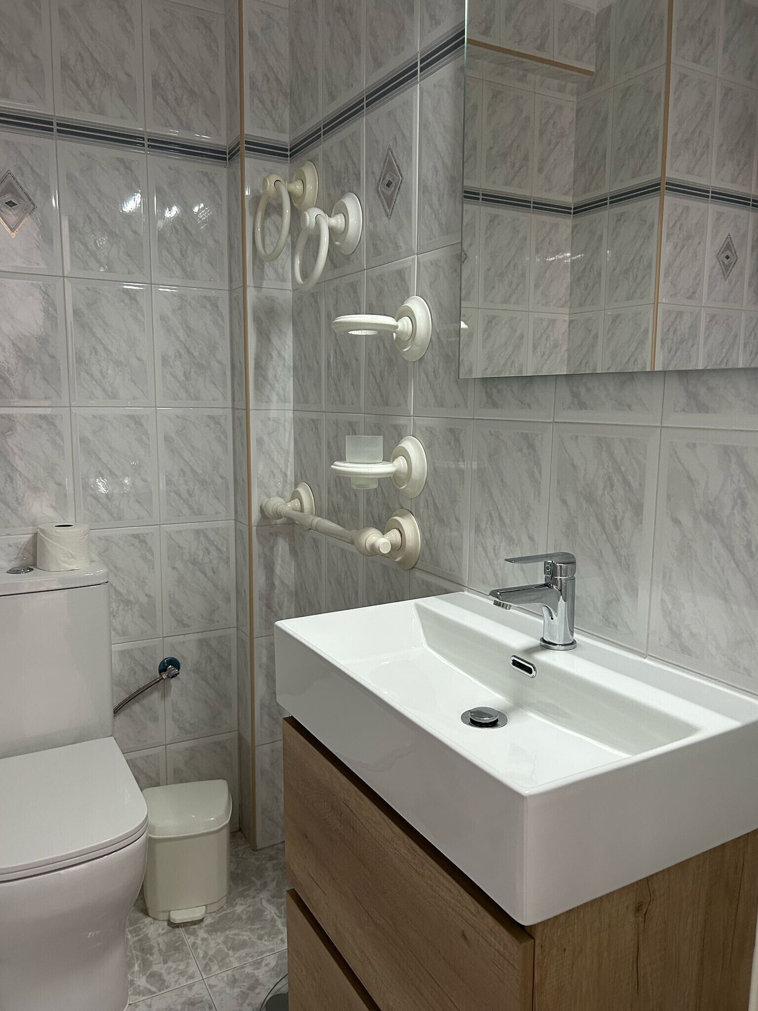 Ein modernes Badezimmer mit Waschbecken, Spiegel und Toilette.