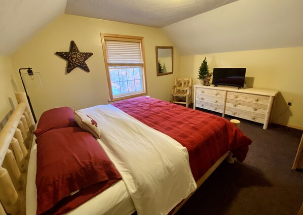 A bedroom with a bed, dresser, TV, star decoration, and window. - ADK Lake House Vacation, Cozy 5 Bedroom & 2 Bath (Old Forge)