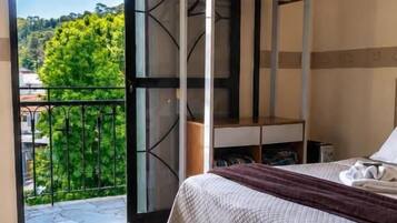 Une chambre à coucher avec un lit, une fenêtre et un balcon.
